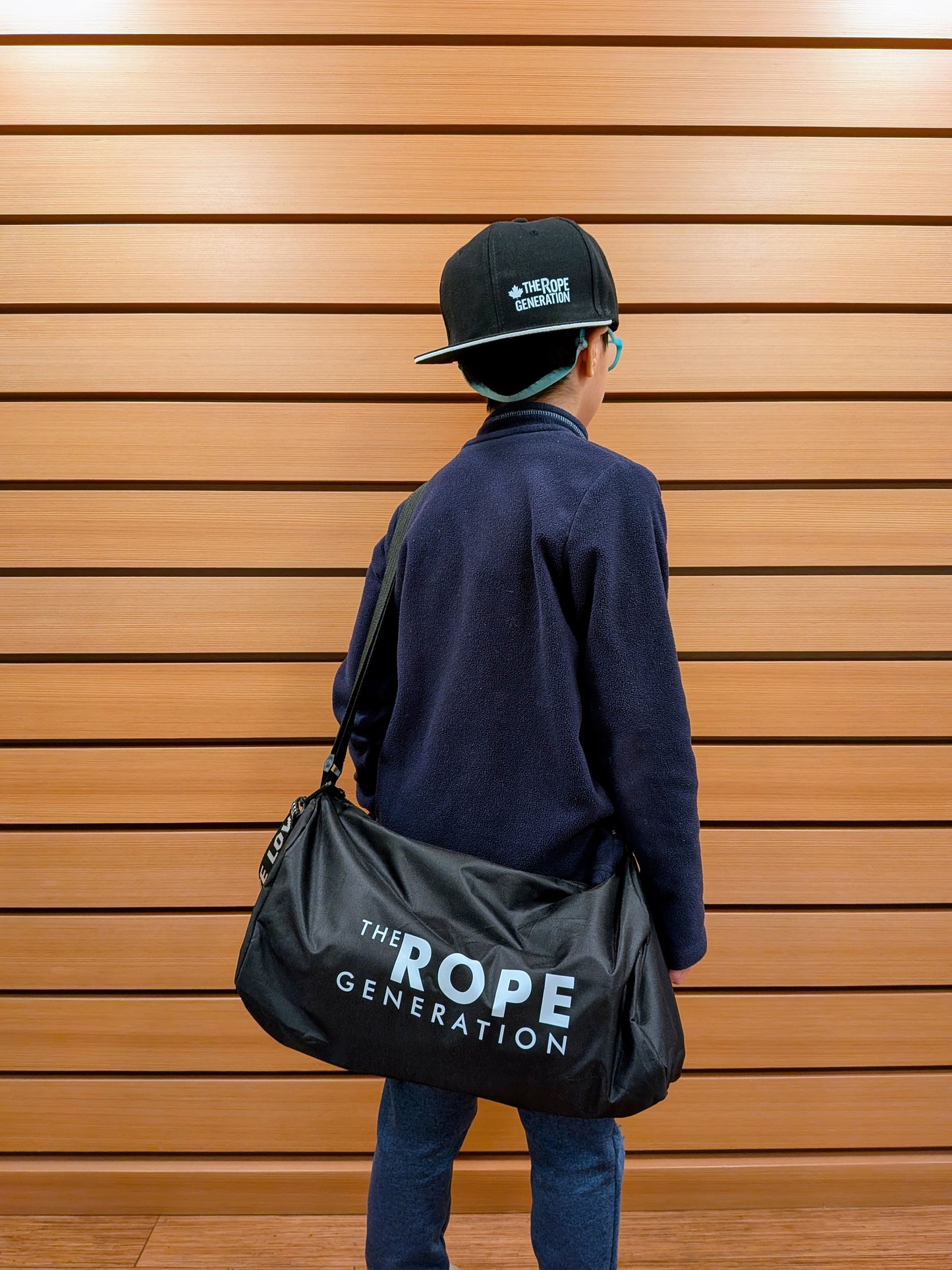 Child carrying The Rope Generation Crossbody Duffle Bag