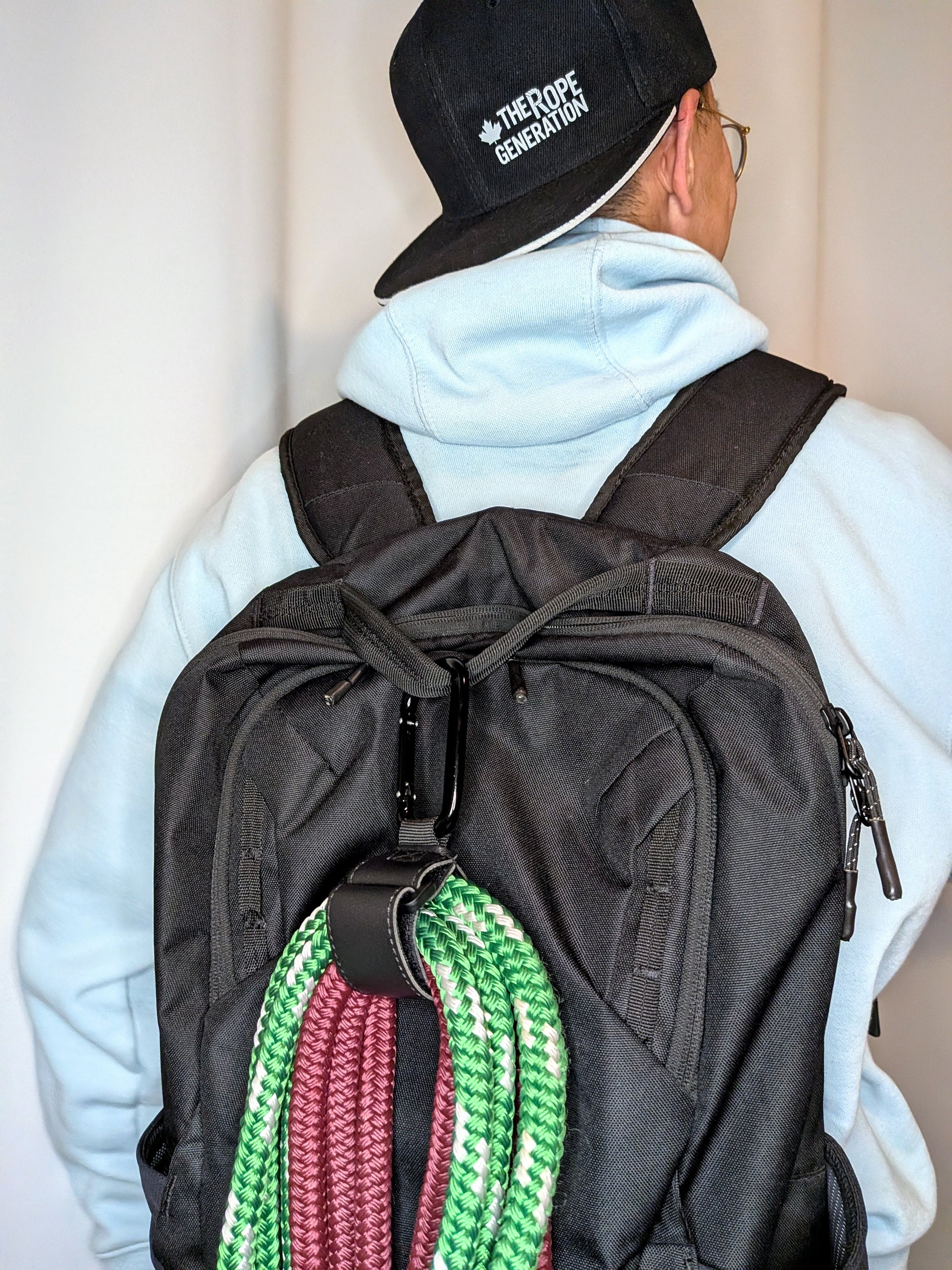Man carrying flow ropes using a flow rope clip hook on a bag