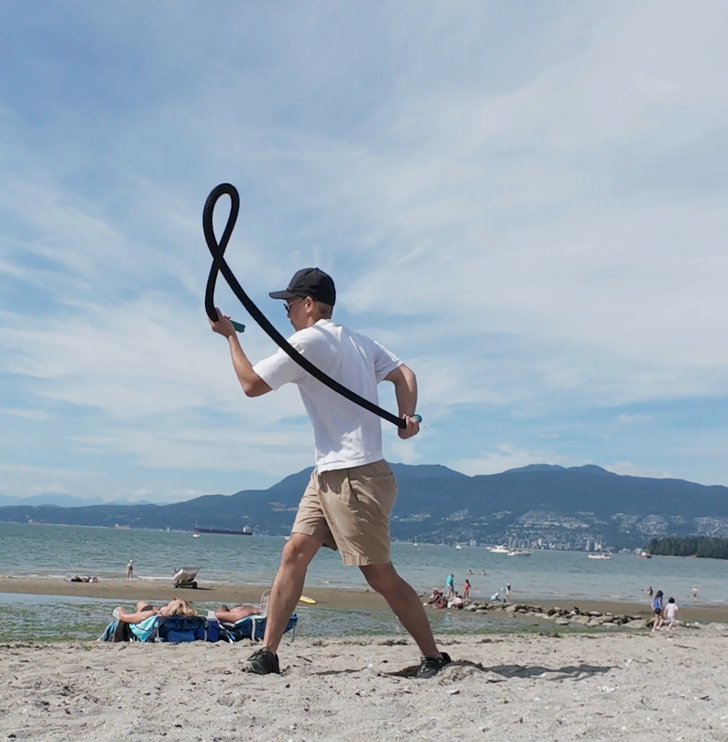 Guy swinging a heavy rope flow rope