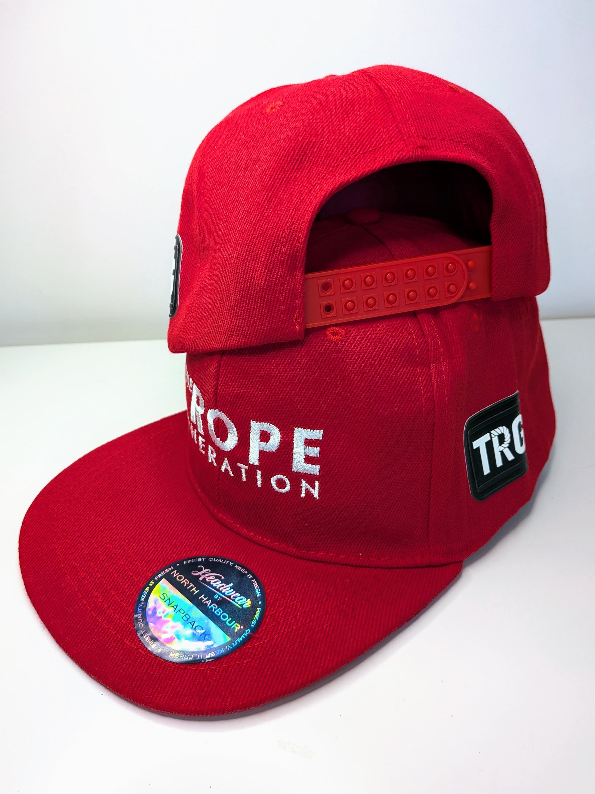 Red flat brim snap back cap with the words the rope generation