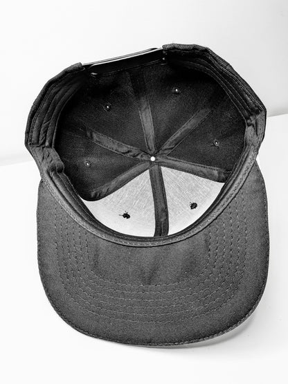 Underside of a black flat brim snap back cap